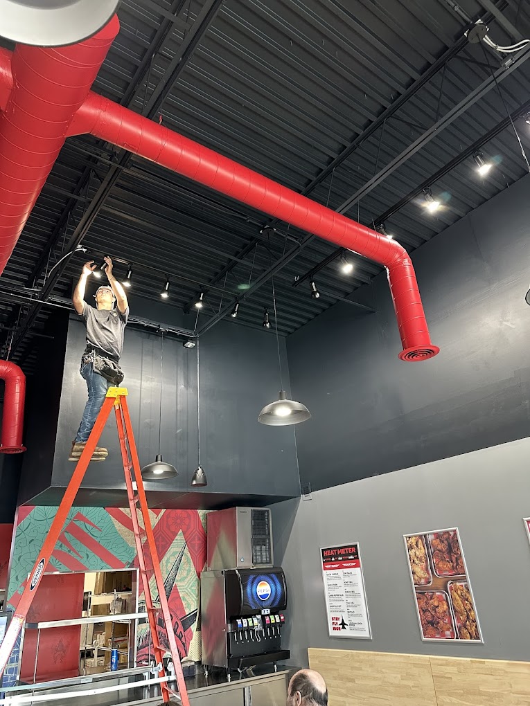 electrician installing light fixtures in a restaurant