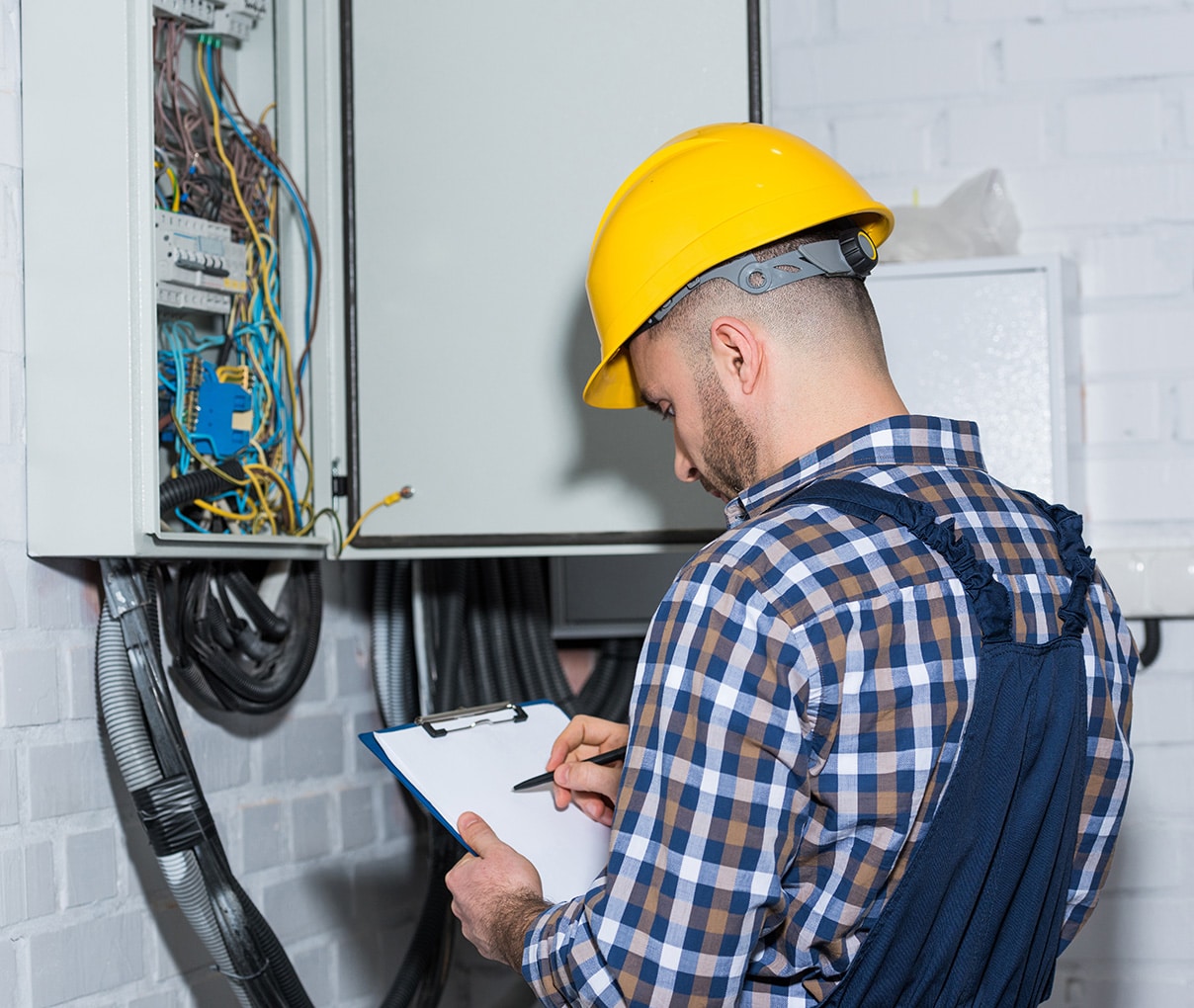 electrician checking electric panel and making notes