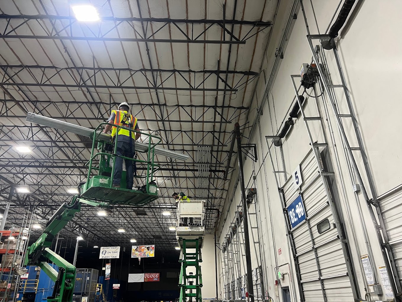 an electrician working on industrial lights on a construction lift