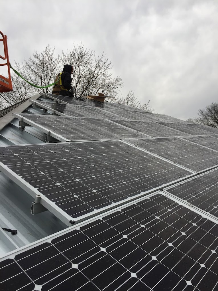 technician checking solar panels installed on rooftop